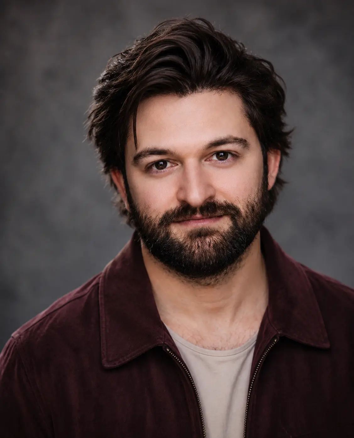 Headshot of actor Daniel Broderick in a burgundy jacket